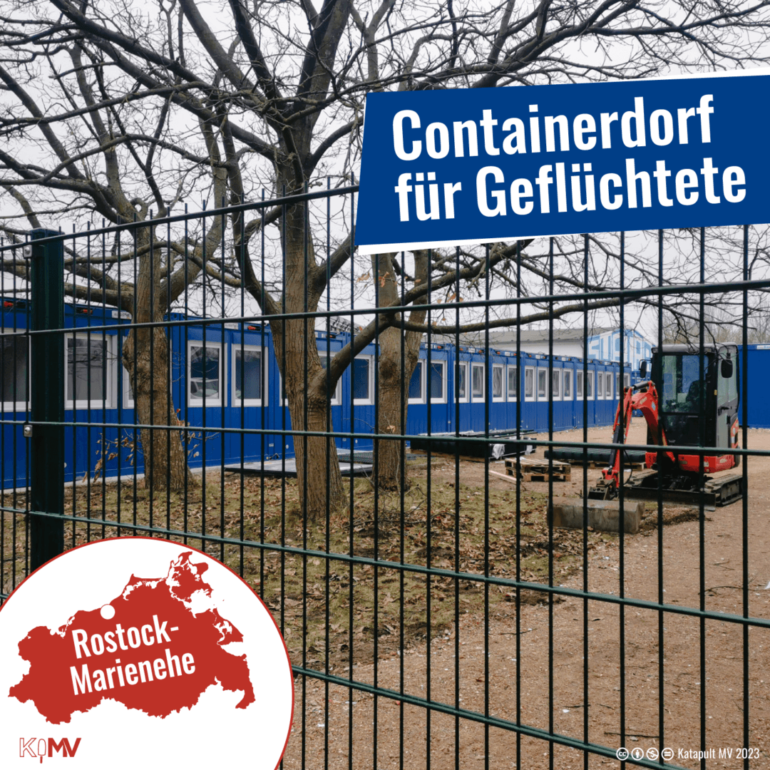 Foto von zwölf aneinandergereihten blauen Containern hinter einem stabilen Bauzaun