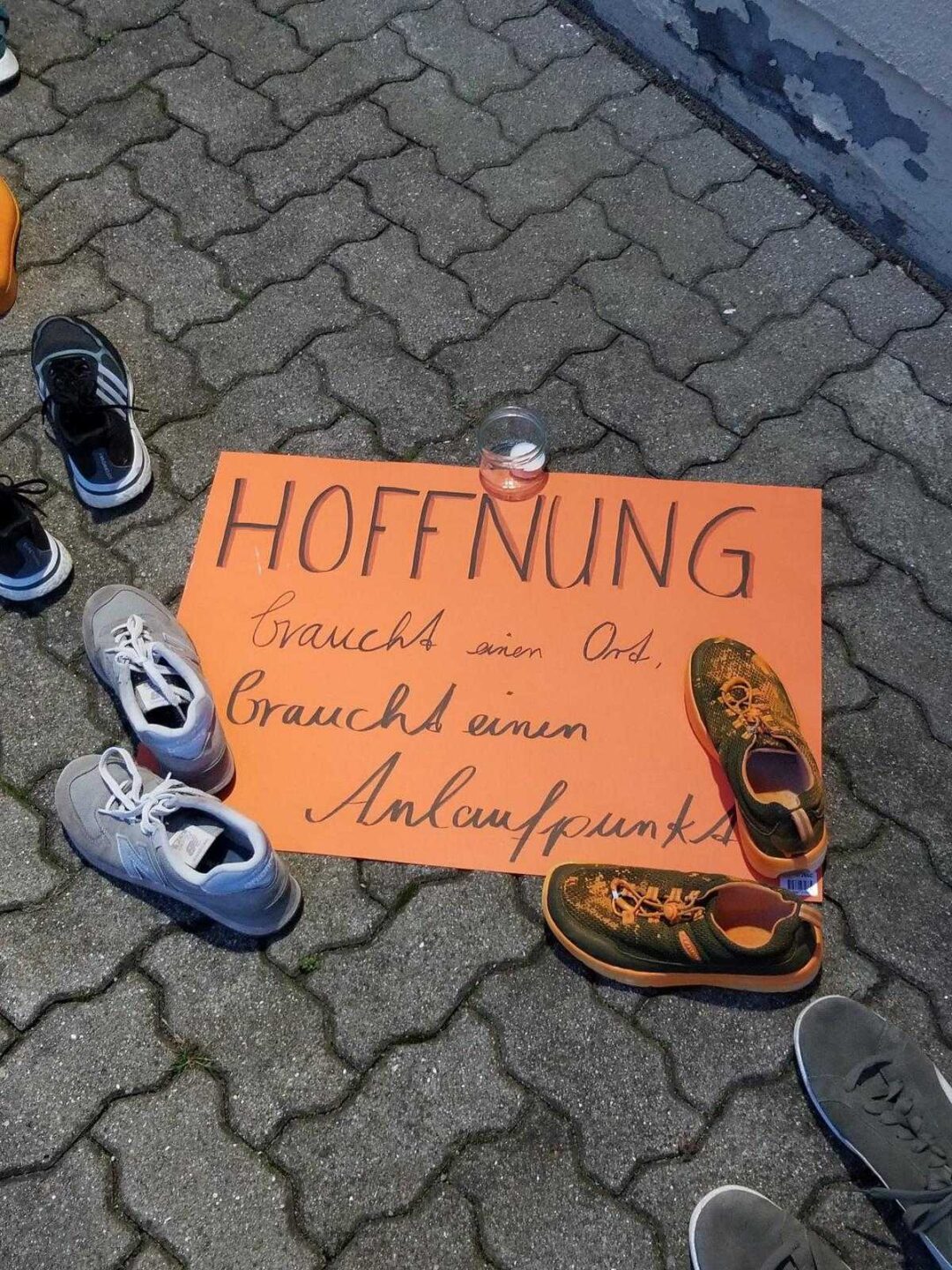 Das Foto zeigt einzelne Schuhpaare einer Protestaktion gegen die Schließung der Beratungsstelle für Betroffene häuslicher Gewalt in Grevesmühlen (Mecklenburg-Vorpommern). Auf einem Schild in der Mitte steht: Hoffnung braucht einen Ort, braucht einen Anlaufpunkt.