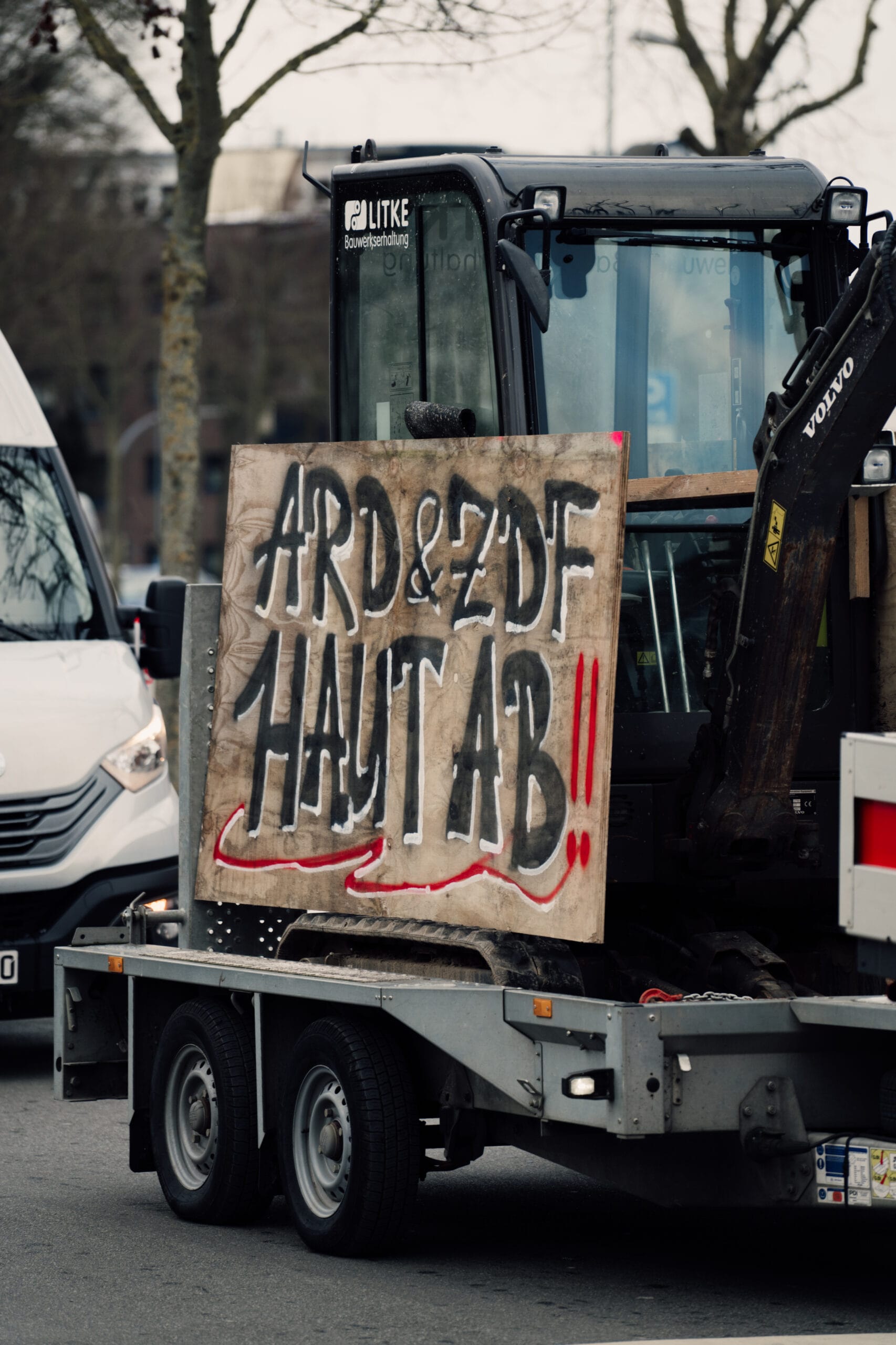 Bagger mit einem Holzschild, auf dem steht: 