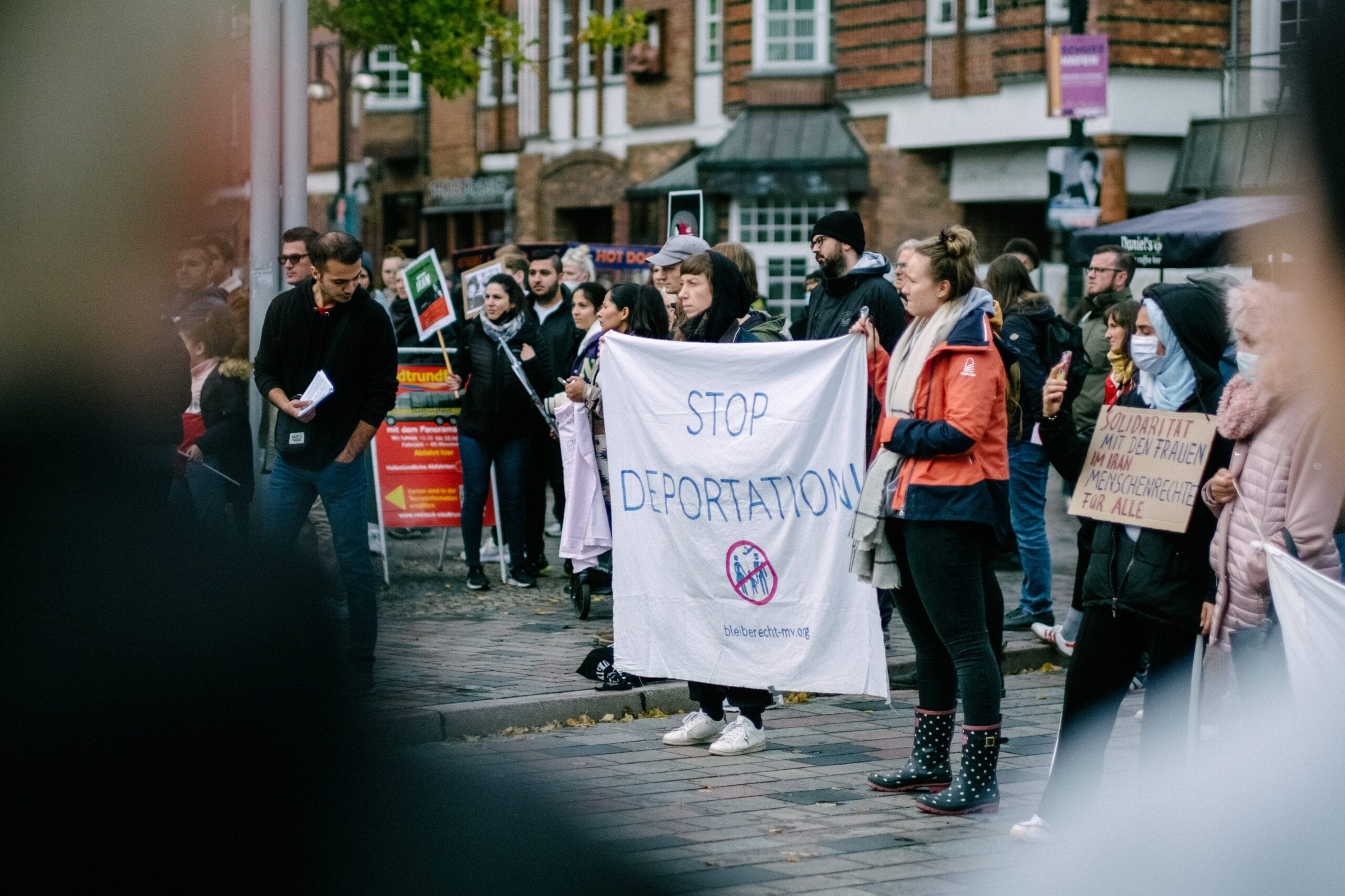 Personen halten ein Transparent mit der Aufschrift “Stop Deportation! bleiberecht-mv.org”