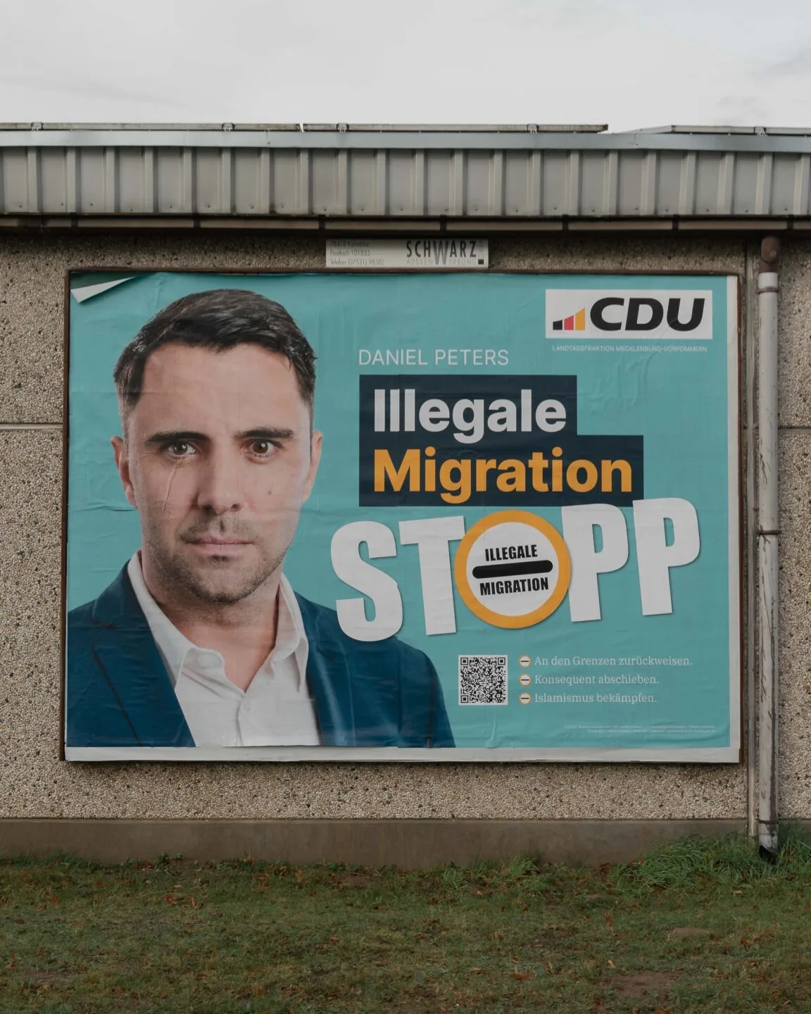 Foto von einem Wahlplakat der CDU MV. Zu sehen sind ein Foto von Daniel Peters und in großer Schrift: "Illegale Migration Stopp"