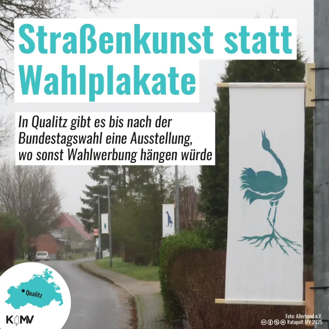 Zu sehen ist ein Foto, dass eine Straße in der Gemeinde Qualitz (Landkreis Rostock) zeigt. Dort sind die Straßenlaternen nicht mit Wahlplakaten, sondern mit Kunst behängt.