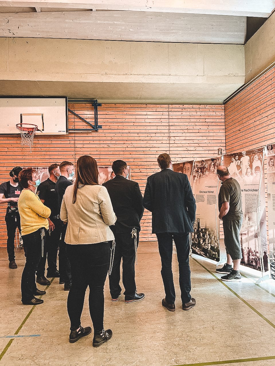 Einer der inhaftierten Ausstellungsbegleiter führt die Mitarbeitenden der JVA Stralsund durch die Anne-Frank-Ausstellung in der Sporthalle der Haftanstalt. Er ist einer von sechs Freiwilligen in Stralsund, die sich in dem bundesweiten Projekt gegen Antisemitismus während ihres Freiheitsentzugs engagieren. Foto: Anna Hansen