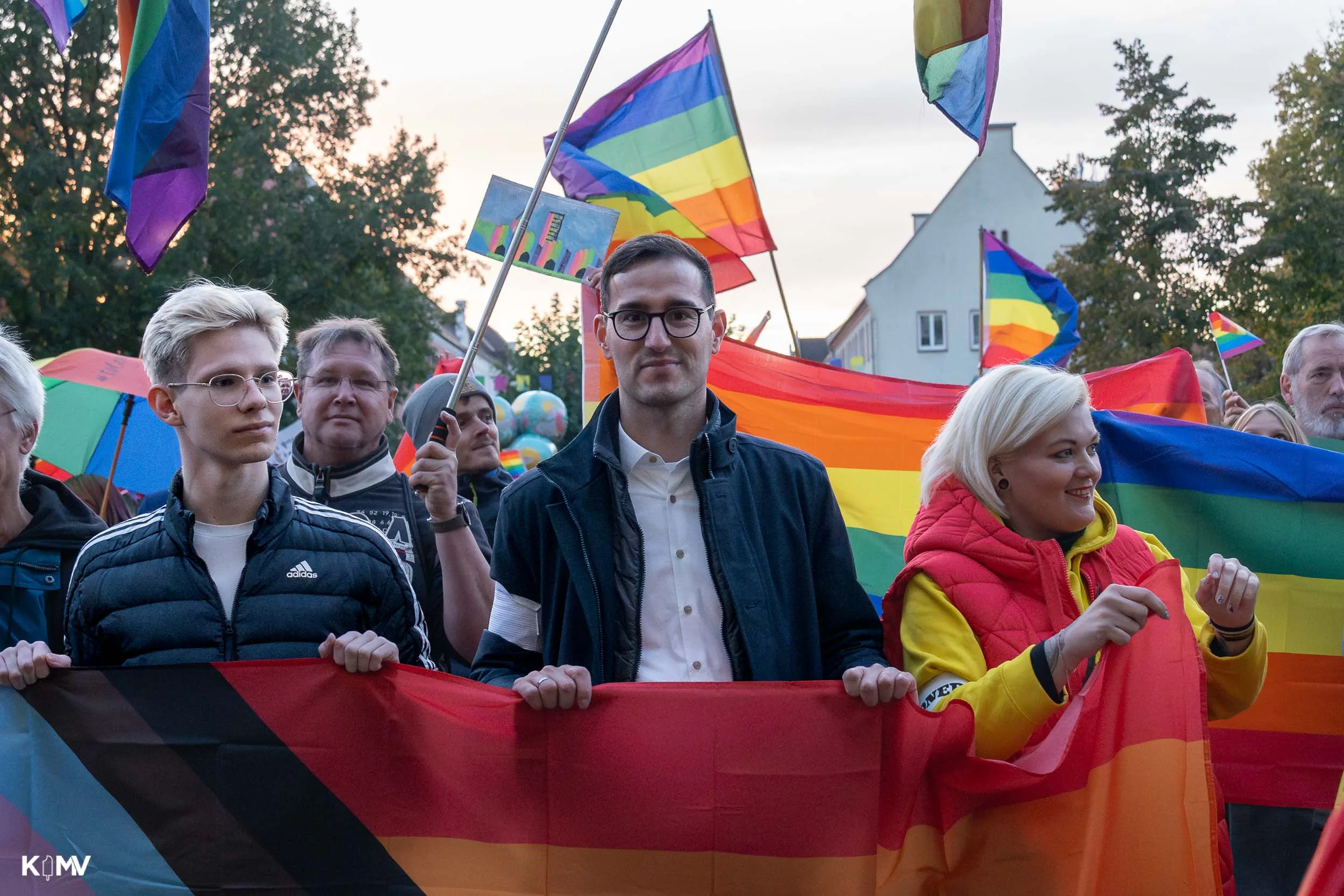 In der Menge zwischen Regenbogenflaggen hält unter anderem der Vorsitzende des queer-NB-Vereins, Marcel Spittel, eine Regenbogenfahne. 