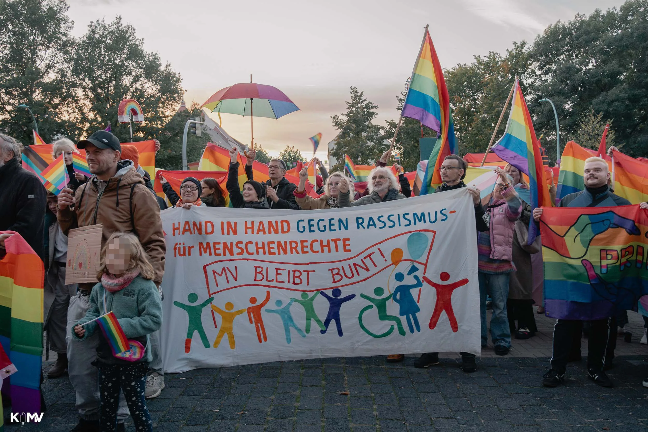 Zu sehen ist eine große Menschenmenge mit vielen Regenbogenflaggen. 