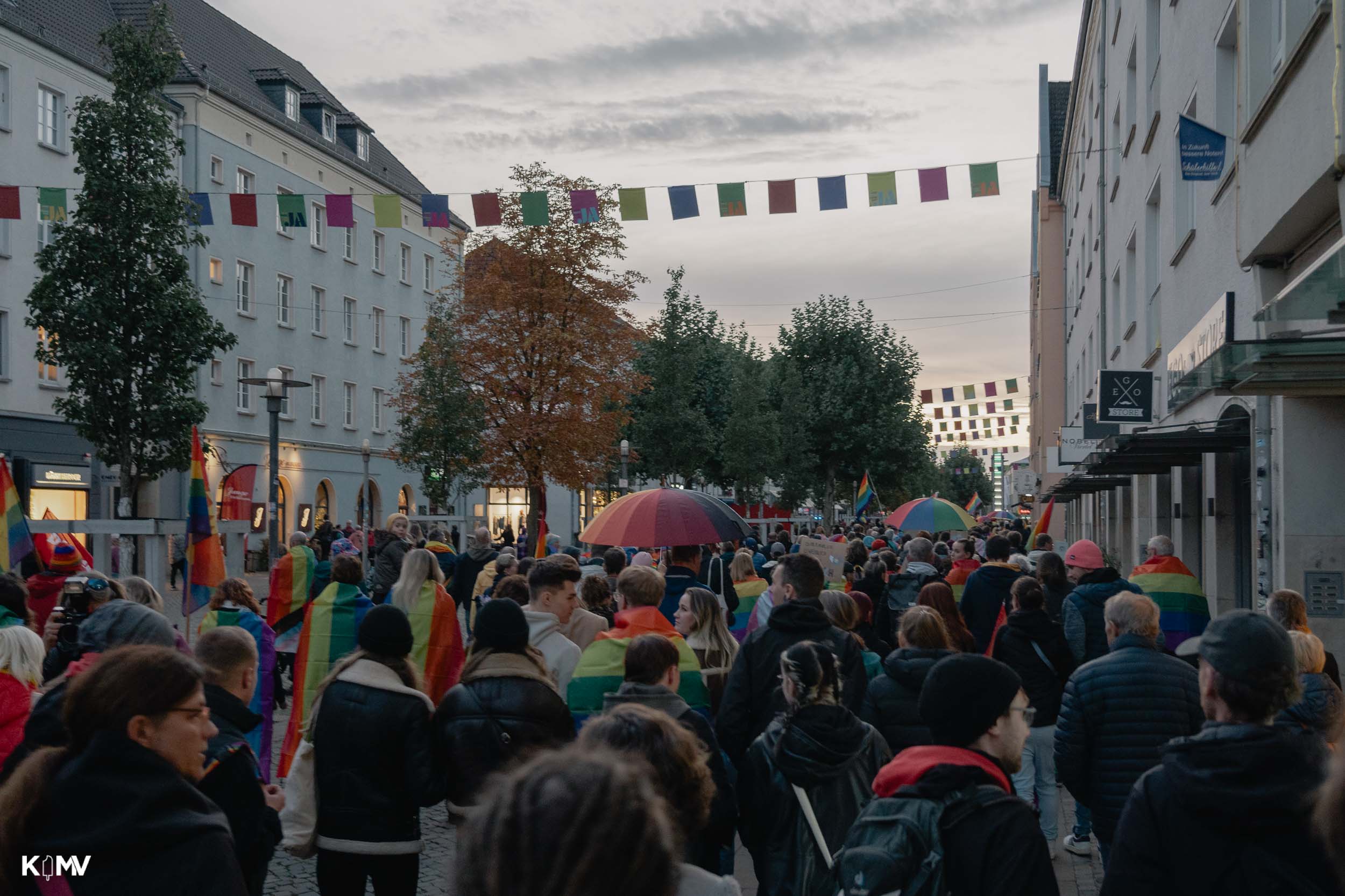 Man sieht die Menschenmenge durch die Einkaufsstraße ziehen. 