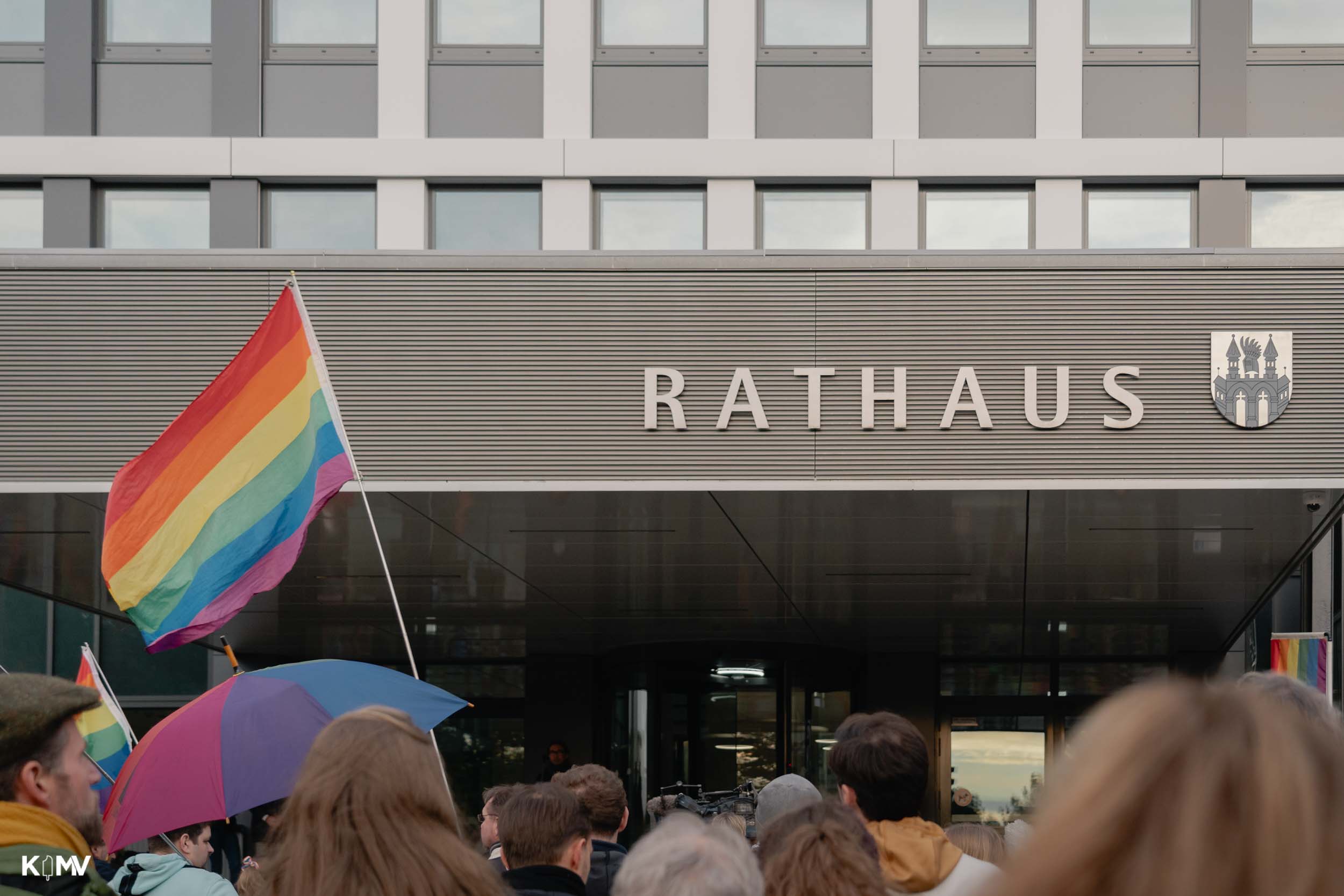 Zu sehen ist der Eingangsbereich des Rathauses in Neubrandenburg, umringt von Regenbogenflaggen. 