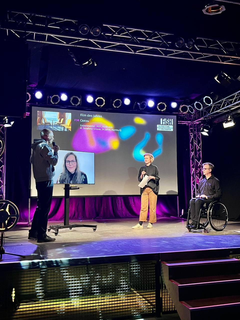 Festivalleiter Arne Papenhagen (links) mit Regisseurin Serafima Orlova (online) und der Jury zum JUNGER FILM Wettbewerb. Ihr Film „Connection“ gewann den Hauptpreis zum „Film des Jahres“.