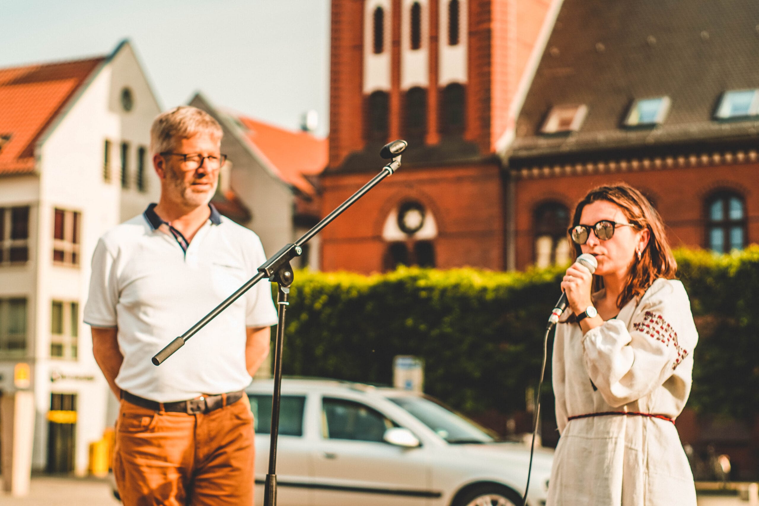 Foto; Der Oberbürgermeister der Stadt Greifswald und Mahnwachenorganisatorin Mariana Yaremchyshyn sind zu sehen. Sie spricht in ein Mikrofon.