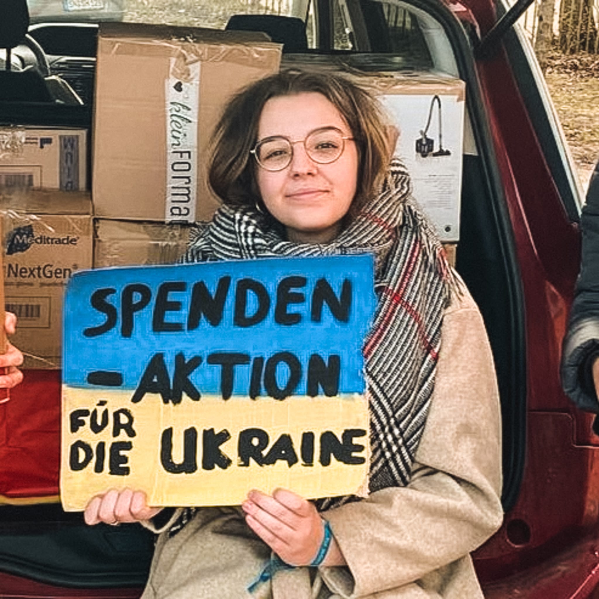 Karolina Życzyńska mit einem blau-gelben Schild mit der Aufschrift 